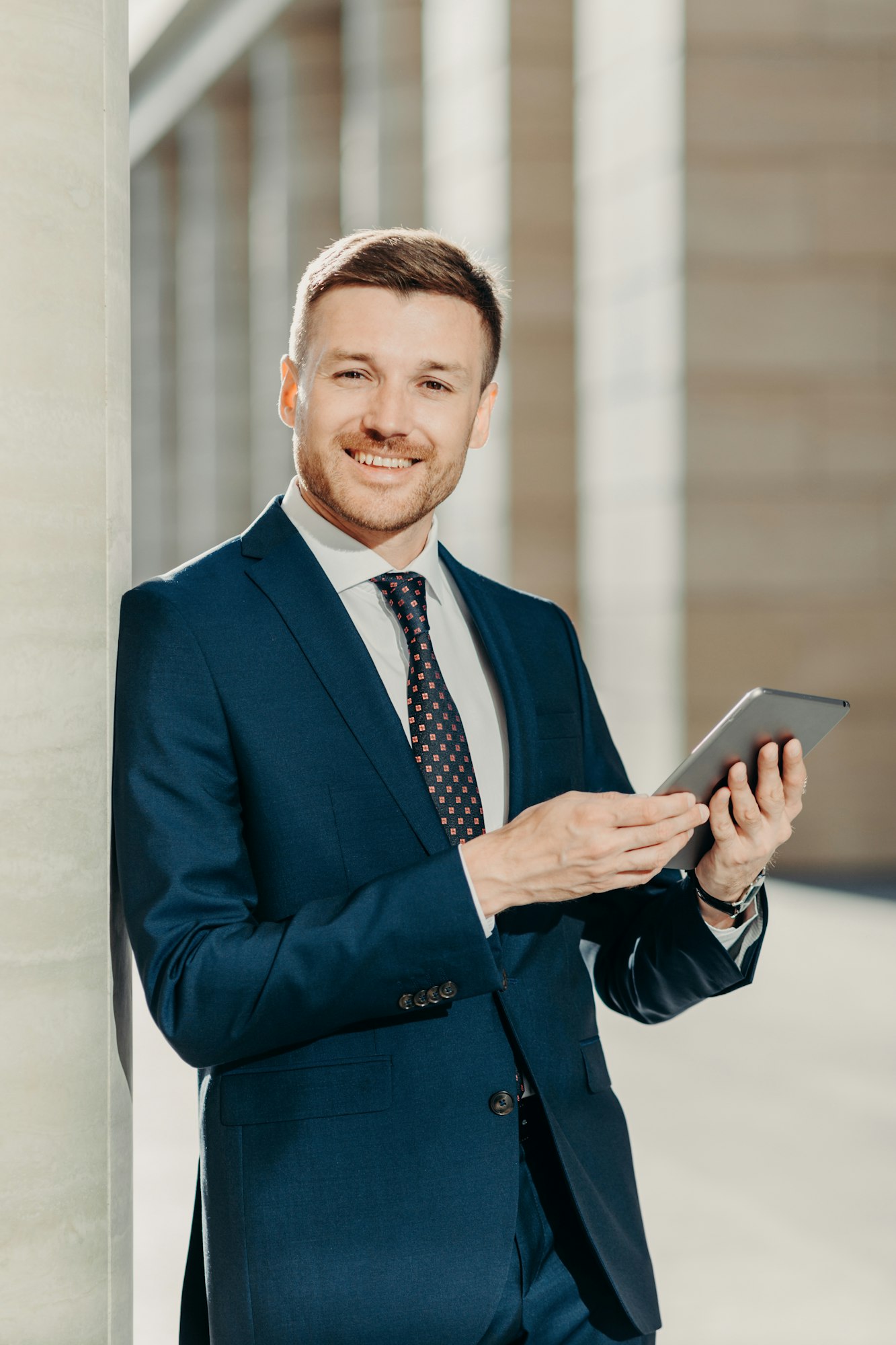 Handsome male economist searches information online on digital tablet